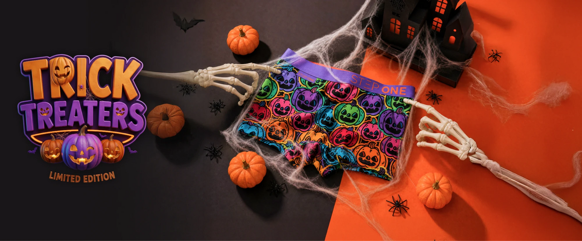 Trick Treaters limited edition: the kids pumpkin-print trunk caught in cobwebs between two skeleton hands, with mini pumpkins, spiders and a haunted house on black and orange